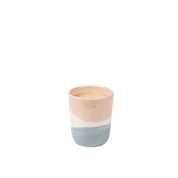 The Sweet Grace Collection Candle #041 by Bridgewater Candle Company is a small, round ceramic holder with pastel pink, white, and blue color blocks. It contains an unlit soy-blend wax candle and is shown against a plain white background.