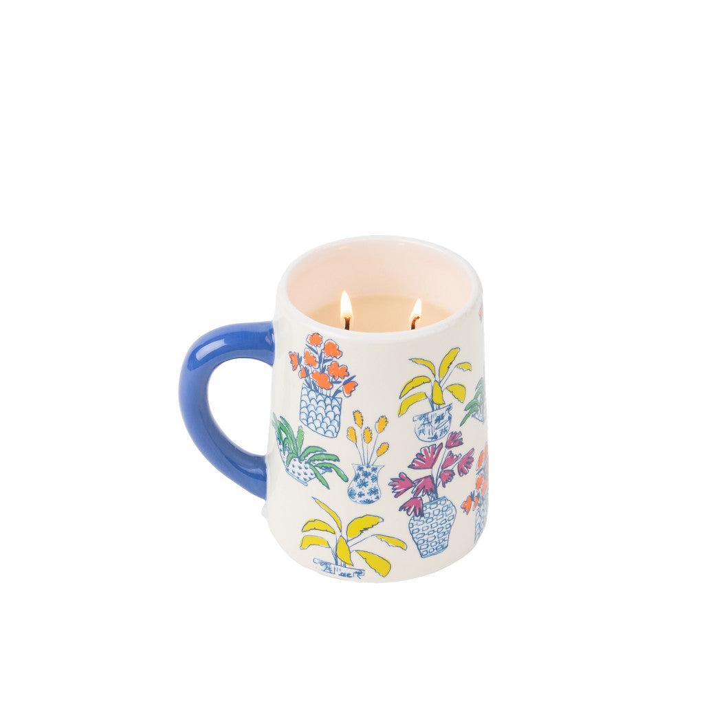The Bridgewater Candle Company Sweet Grace Collection Candle #054 is a ceramic mug with a blue handle and potted plant art, repurposed as a soy-blend candle with two wicks—an ideal gift for any plant mom. The background is plain white.