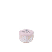 A small, round pink travel-sized tin candle from Bridgewater Candle Company, Sweet Grace Collection Candle #059, features a white and beige abstract pattern, minimalist design, labeled “sweet grace,” and is crafted with soy-blend wax.
