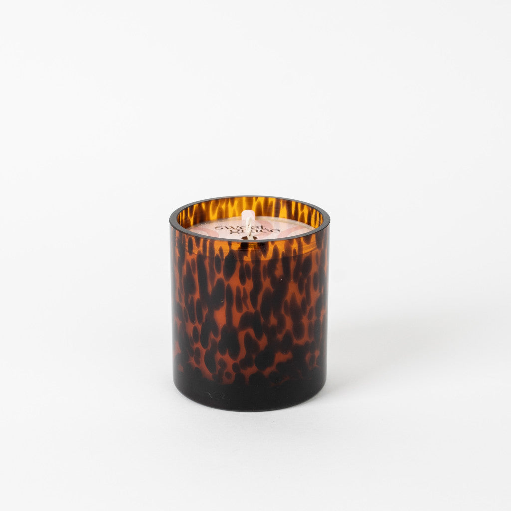 A brown animal patterned candle jar with a white candle visible from the top.