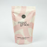 A pink and cream resealable pouch labeled “Sweet Grace Soaking Salts” by Bridgewater Candle contains a blend of Epsom and Pink Himalayan Sea Salt, with a circular seal and 2 lb (907 g) weight displayed on a plain white background.