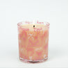 The Sweet Grace Pink Bow Candle by Bridgewater Candle features delicate white and pink bow designs on a glass holder. Made with soy-blend wax, this charming candle is displayed against a plain white background.