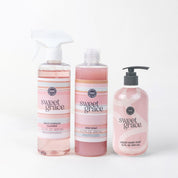 The Sweet Grace Scrub & Cleanse Bundle features a Multi Surface Spray, dish soap, and hand soap in pink bottles, displayed together against a white background to add elegance and fragrance to your cleaning routine.
