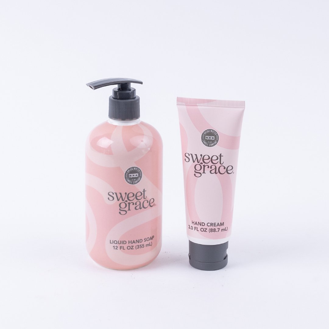 The Sweet Grace On Hand Bundle includes two pink hand care essentials: a 355 ml Liquid Hand Soap with a pump and an 88.7 ml Hand Cream, both featuring chic white and light pink abstract designs—ideal for your hand care routine.