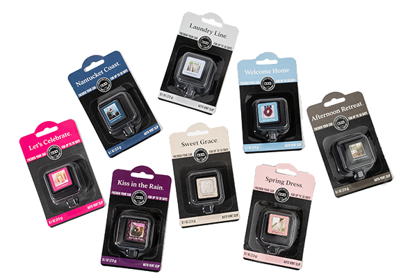 Nine scented wax melt packs arranged on a white background, each in different colored packaging with unique scent names such as “Let’s Celebrate,” “Sweet Grace,” and “Spring Dress.”.