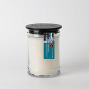 The Bridgewater Candle "I'll Be Home" 18oz Large Jar Candle features soy-blend wax, a black lid, and a blue-and-white label on the lid—perfect for enhancing your home's fragrance, shown against a plain white background.