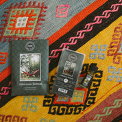 The Bridgewater Candle Company Afternoon Retreat Flameless Bundle, including a scented sachet, wax bar, and home fragrance oil, sits on a colorful geometric-patterned rug in red, yellow, black, and orange.
